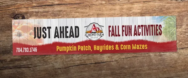 Almond Farm road sign that reads" just ahead. Fall fun activities. Pumpkin patch, hayrides, and corn mazes